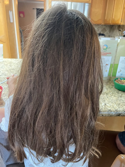 A photo showing the child's hair before using the brush, tangled and knotted