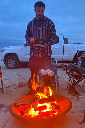 Reviewer holding the fishing pole with marshmallows roasting over the campfire