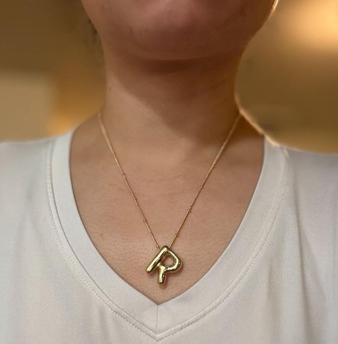 The reviewer is seen wearing a gold R necklace.
