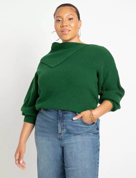 Model wearing a pointed collar sweater in green, styled with a pair of jeans