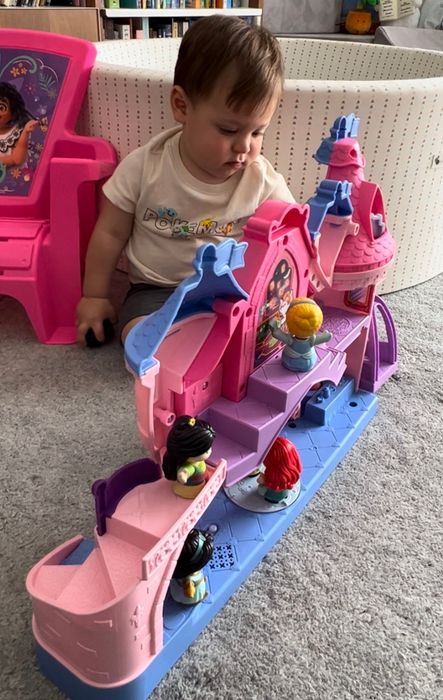 A child enjoying playtime with a Disney Princess castle.