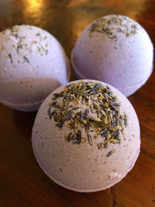 three lavender bath bombs topped with buds