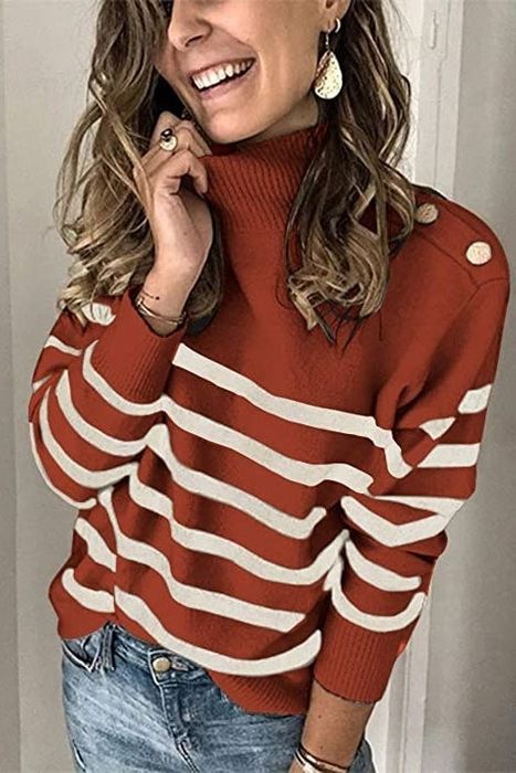 A model is dressed in a rust and white striped sweater with metallic shoulder buttons.