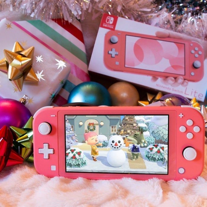A pink Nintendo Switch Lite with Animal Crossing displayed on the screen