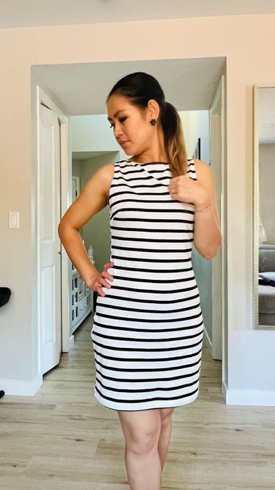 The reviewer is dressed in a black stripe dress.