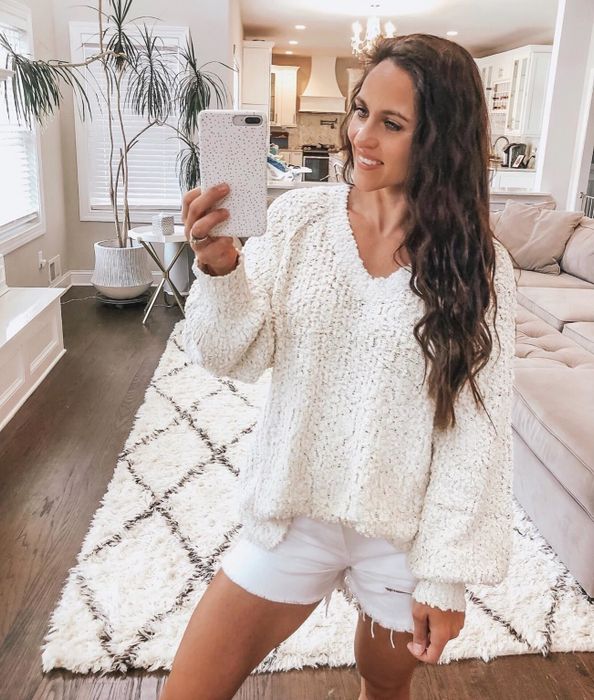 A reviewer rocking the popcorn sweater in crisp white, perfect for a cozy, classic look.
