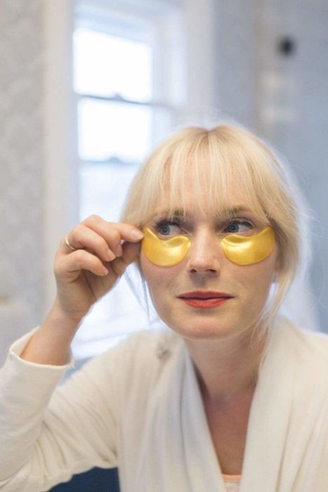 a model demonstrating the application of gold under-eye masks