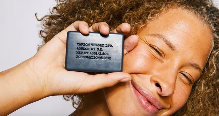 Model holding the cleansing bar