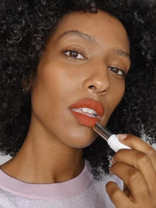 A model applying red lipstick.