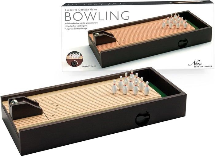 A small bowling lane placed next to its packaging