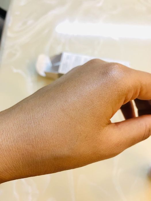 The same reviewer demonstrates the sunscreen's ability to blend seamlessly into the skin, leaving no white cast behind.