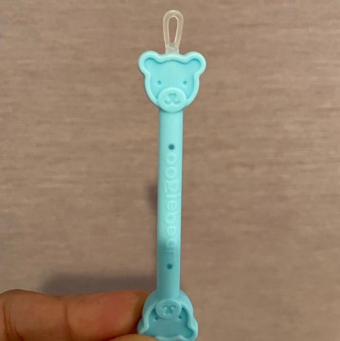 A close-up view of the bear-shaped booger-cleaning tool.