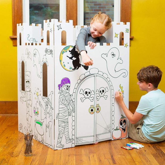 Models coloring in the cardboard haunted castle playhouse.
