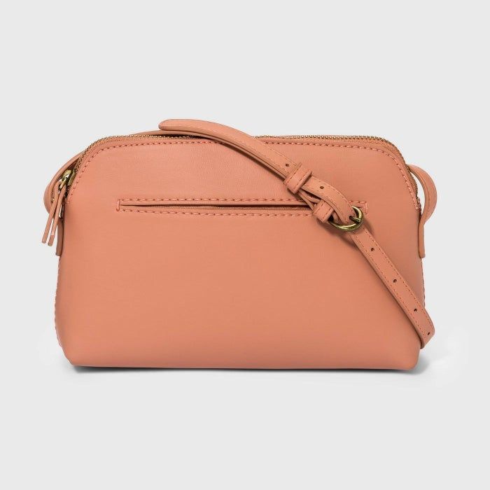 The purse in a soft, peachy pink hue.