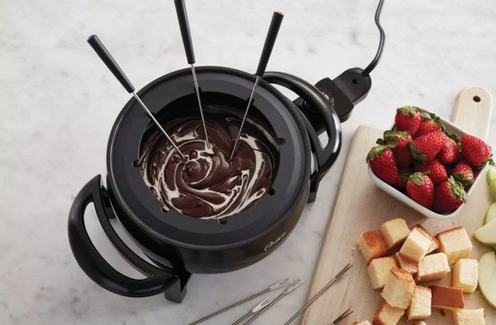 The fondue pot filled with melted chocolate, ready for dipping.