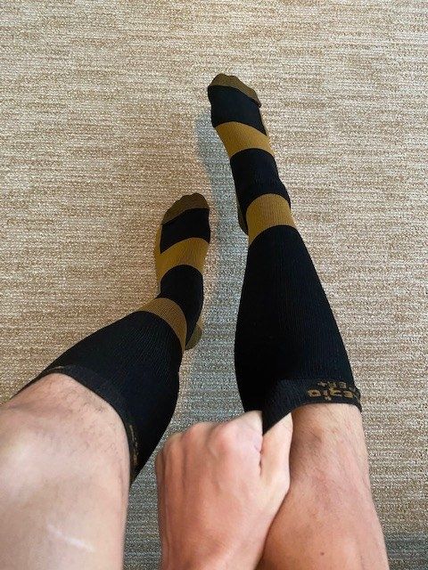 The author pulling one of the copper-infused compression socks up their leg.