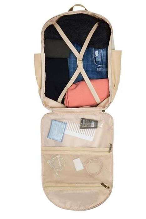 The backpack opens to reveal three interior mesh pockets along with a compression strap for securing items.