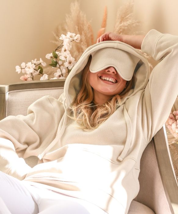 Model dressed in a white hoodie featuring a built-in sleep mask
