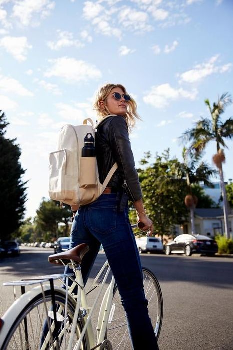 A model showcases the beige backpack.