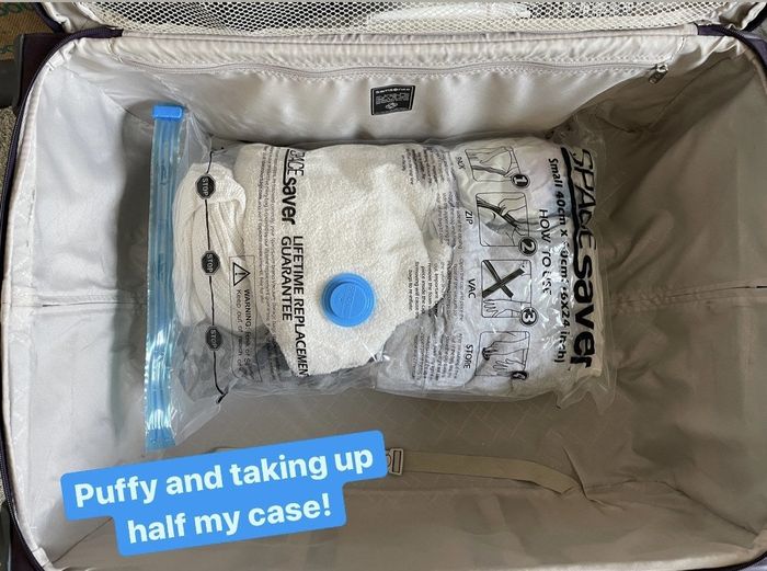 Jasmin's oversized clothes packed into a sealed bag with the text: 'Puffy and taking up half my case!'