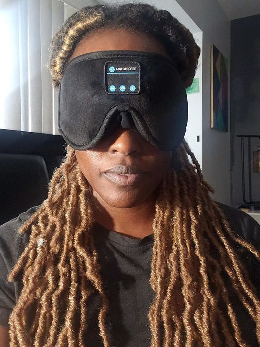 A reviewer wearing the sleep mask for ultimate comfort and relaxation.