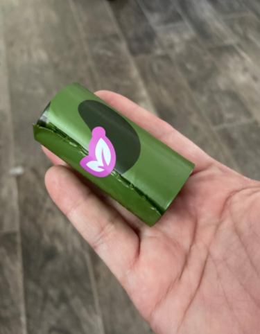 A reviewer holding a roll of poop bags