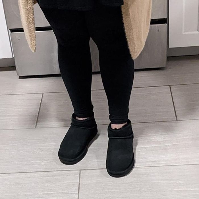 A reviewer styling the boots in black paired with black leggings.