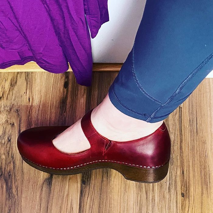 a profile view of a reviewer rocking burgundy clogs