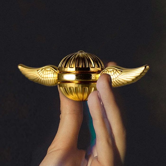 The golden toy shaped like a Flying Snitch with wings sprouting from the sides