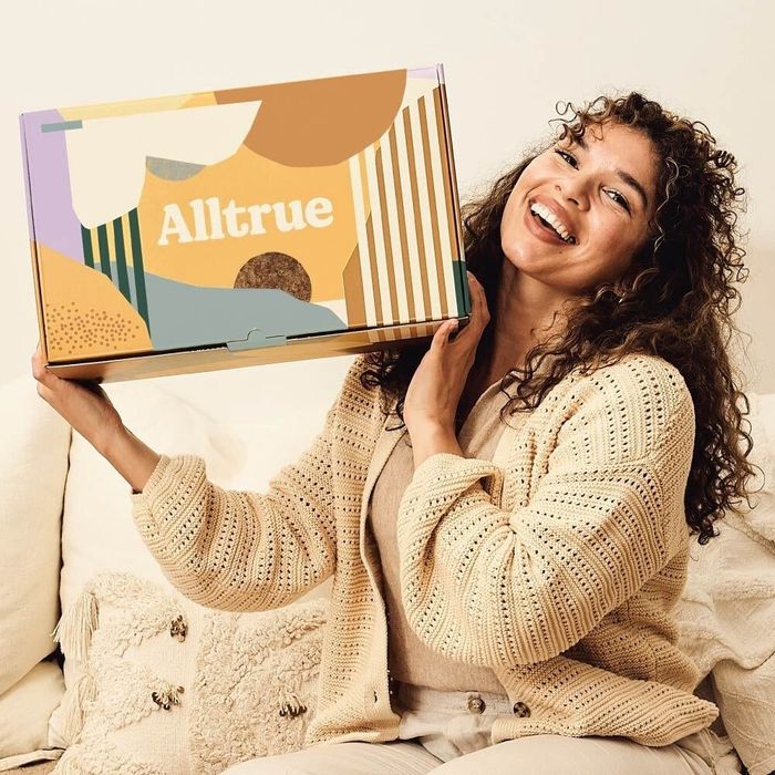 A model holding a printed box labeled 