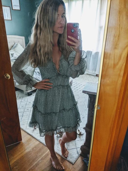 Reviewer wearing the green long-sleeve layered ruffle swing dress