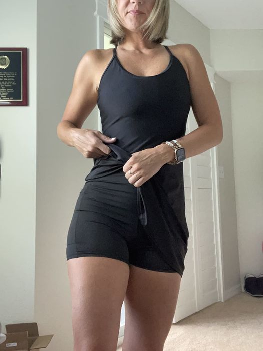 A reviewer is wearing the black workout dress featuring built-in shorts.