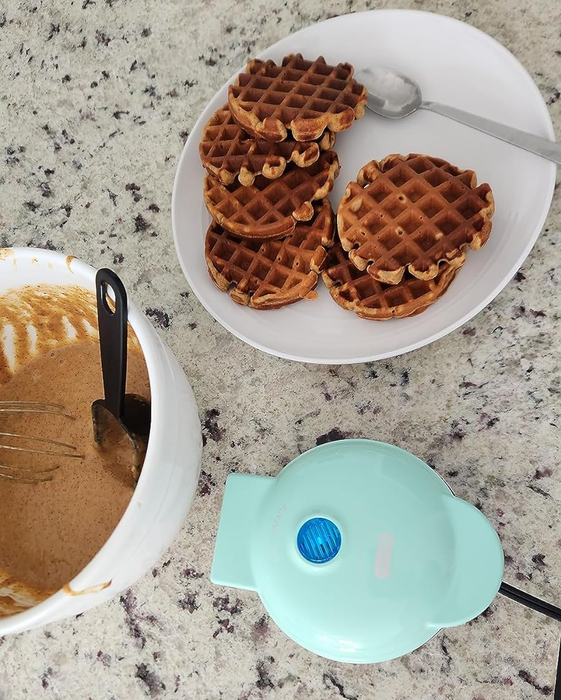 A reviewer's bright aqua blue waffle maker