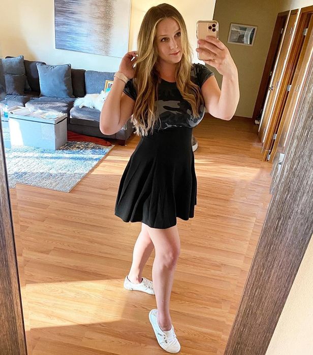 A reviewer wearing the black high-waisted suspender skirt overall dress.