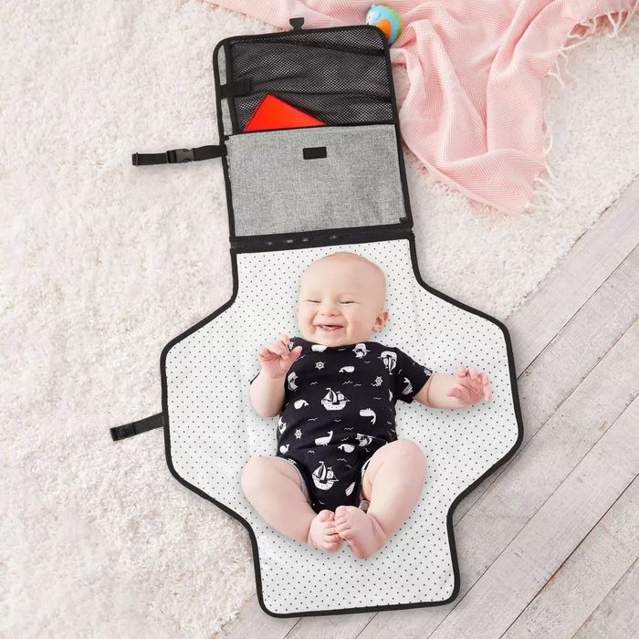 A baby model lying on top of an unfolded diaper changing station.