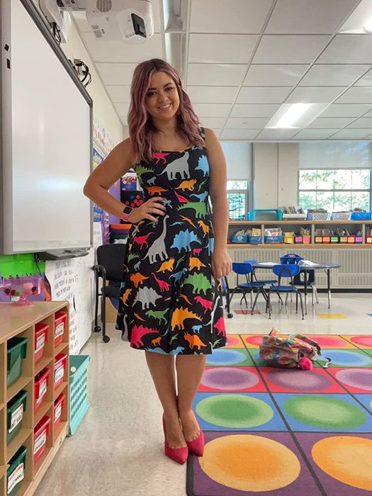 A reviewer is wearing a fun cartoon dinosaur dress.