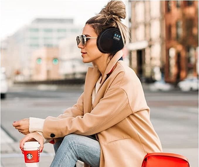 A model wearing black earmuffs with a soft faux fur trim around the ears.