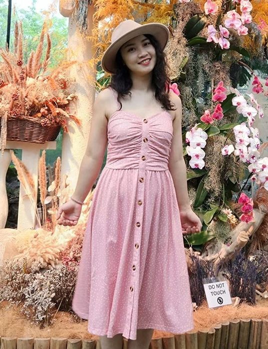 A reviewer is wearing a pink dress.