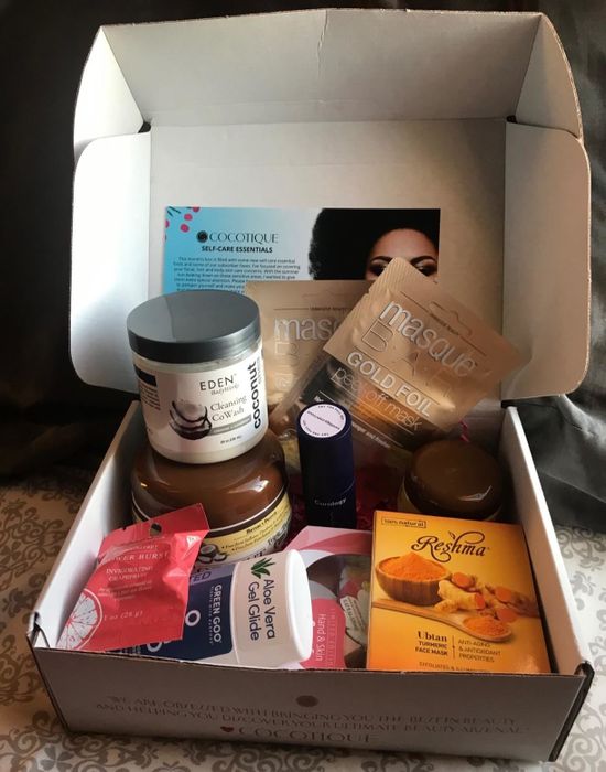 A reviewer’s photo showing an open box filled with self-care products from various brands