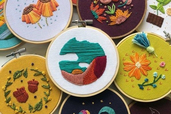 A collection of embroidery hoops, each featuring different, embroidered designs.