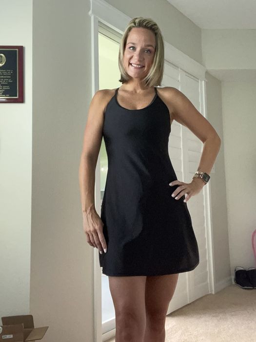 A reviewer is wearing the black workout dress featuring built-in shorts.
