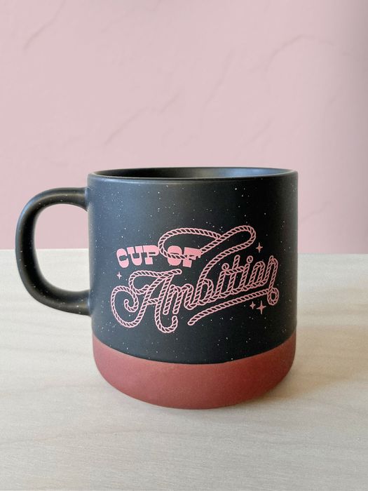 A black and red mug featuring the text