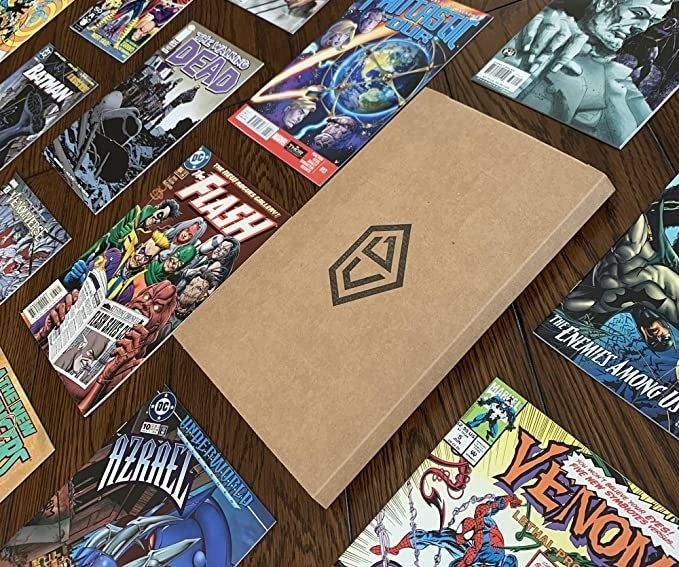 A slim cardboard box sits on a table, surrounded by various comic books in different styles.