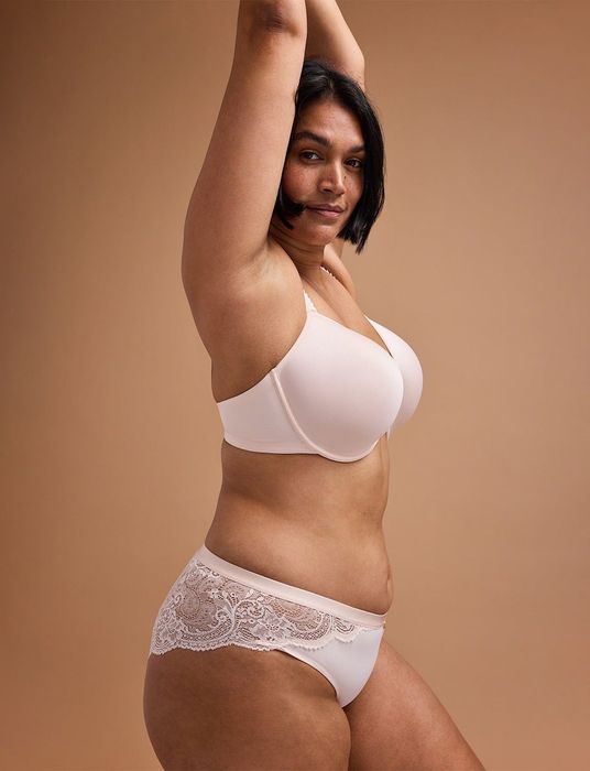 A model showcasing the T-shirt bra in a light pink color.
