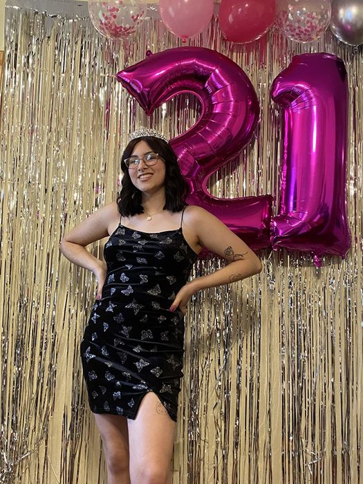 A reviewer is wearing the black cami body-con butterfly dress.