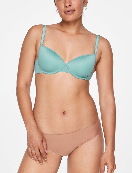 A model showcasing the T-shirt bra in turquoise.