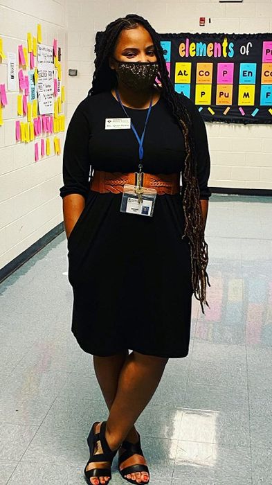 A reviewer dons the sleek, solid black long-sleeve dress.