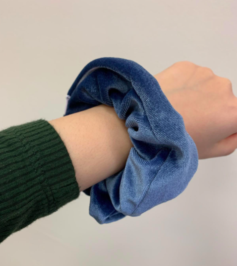 A customer review photo showing the scrunchie comfortably worn on their wrist, ready for use at any time