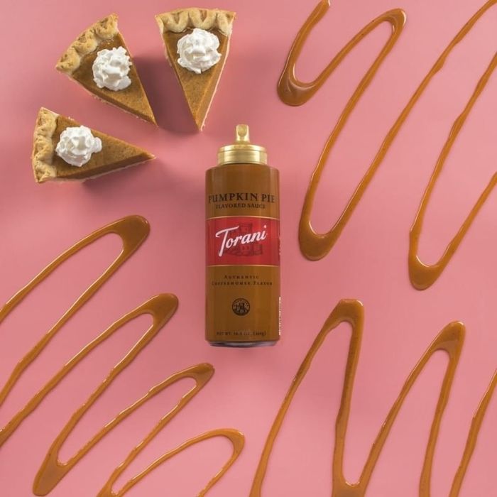 Bottle of Torani's Pumpkin Spice sauce beside slices of pumpkin pie