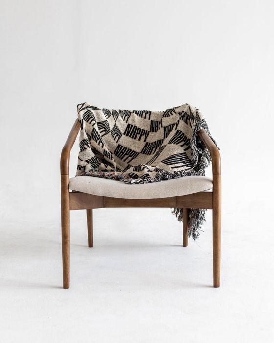 The same cozy blanket draped elegantly over a chair, adding a touch of modern flair to the room.